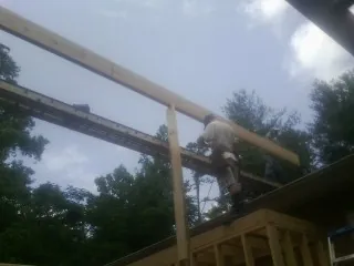 Carpenter setting a ridge beam over a new addition frame — Ice Dam Removal by Roofing Brothers in Piqua