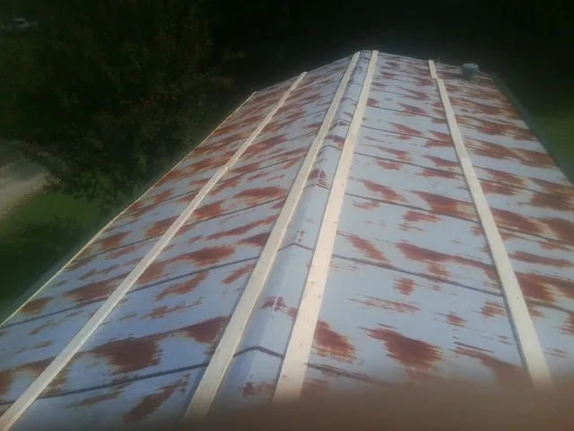 Rusted metal roof panels with new wood purlins before replacement — Storm Damage Roof Repair in Piqua by Roofing Brothers