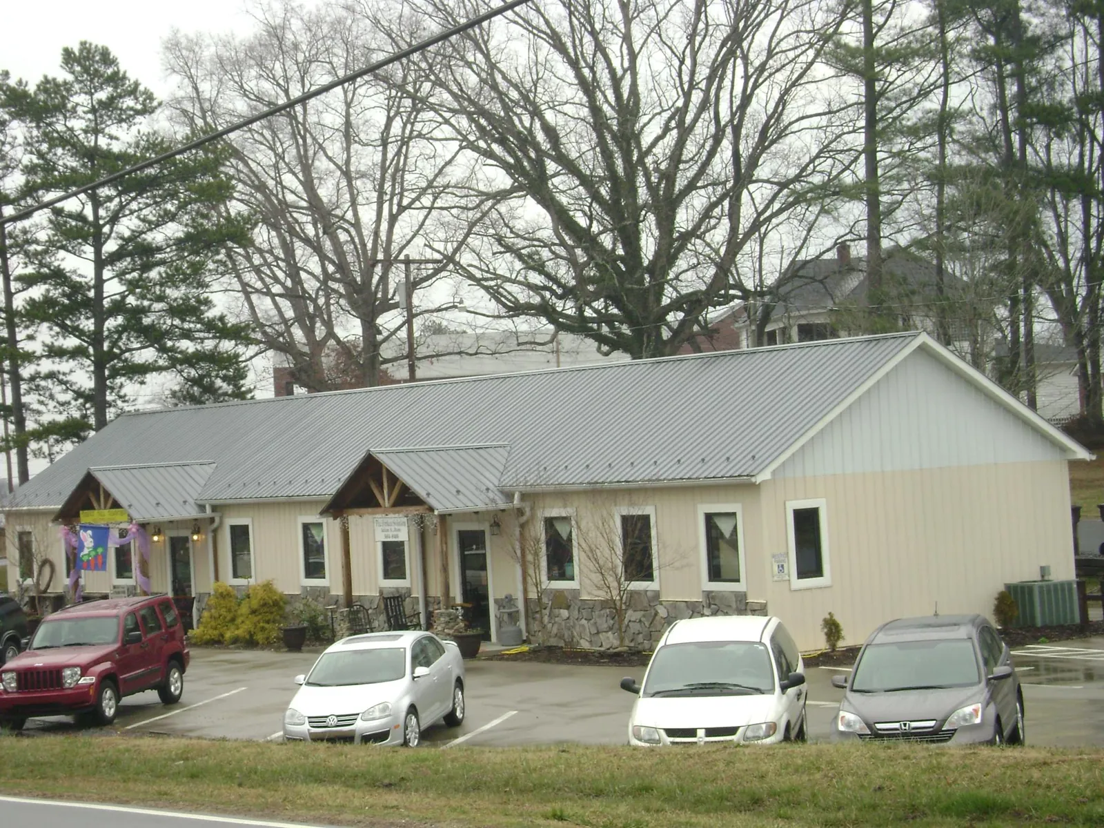 Gray metal roof with timber entry brackets on a small commercial building in Piqua