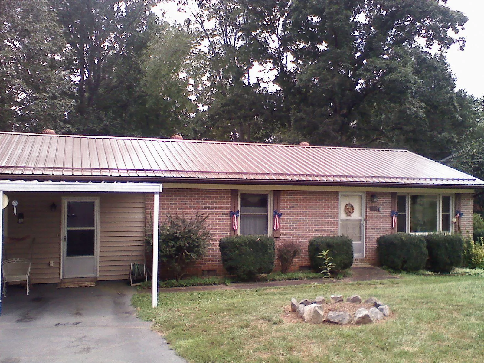 Bronze metal roof and carport on a brick ranch home — Roof Repair work by our crew in Piqua