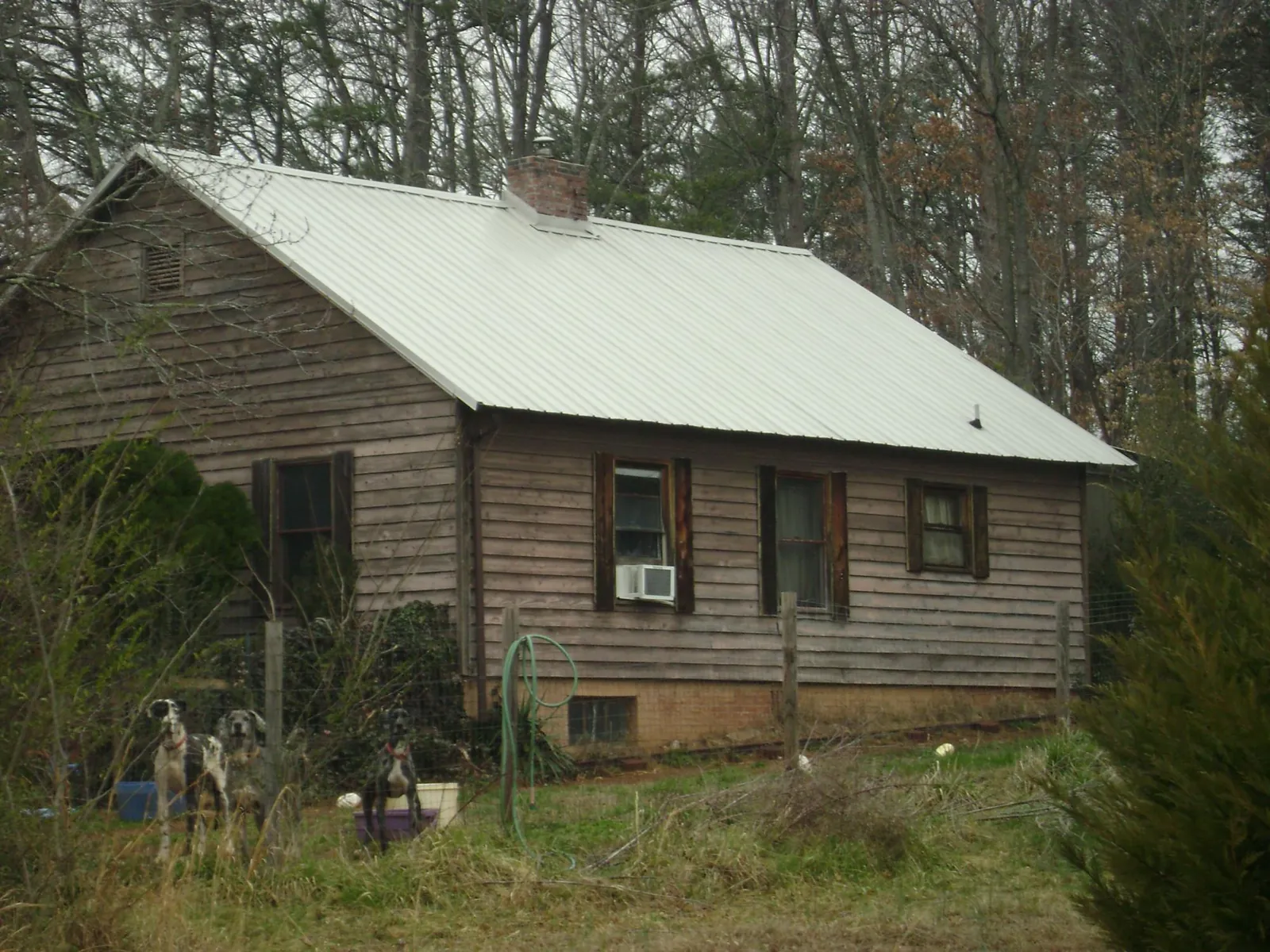 White metal roof on an old wood sided farmhouse, from a Metal Roof Installation job in Piqua